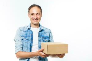 sonriente entrega hombre participación un grande paquete o empaquetar aislado en blanco foto