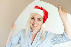 Navidad, Navidad, invierno, felicidad concepto - sonriente mujer en Papa Noel ayudante sombrero con paquete o empaquetar caja foto