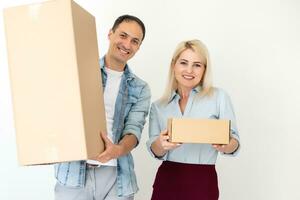 people, delivery, shipping and postal service concept - happy couple opening cardboard box or parcel at home photo