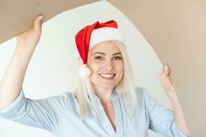 Navidad, Navidad, invierno, felicidad concepto - sonriente mujer en Papa Noel ayudante sombrero con paquete o empaquetar caja foto