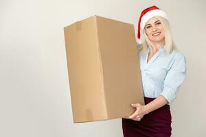 christmas, x-mas, winter, happiness concept - smiling woman in santa helper hat with parcel box photo