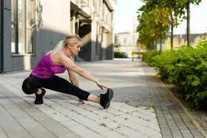 Sport woman doing stretching exercise during outdoor cross training workout photo
