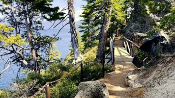 View, POV walking down mountain stone path by lake Tahoe in California. Walking tourist route near the lake in the mountains video