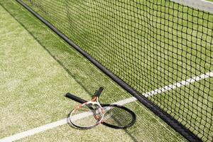 una raqueta de tenis y una pelota de tenis nueva en una cancha de tenis recién pintada foto