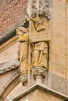 statues of people with a sign on the side of a building photo