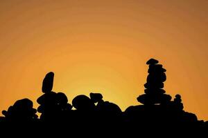 a group of rocks stacked on top of each other at sunset photo