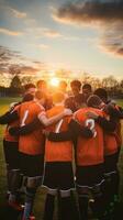 AI generated A group of young soccer players huddled together in a team talk, with the sun setting behind them photo