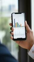 AI generated person hand holding a smartphone with graph chart on the screen, indicating business growth photo