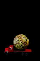 a red truck with a large globe on top of it photo