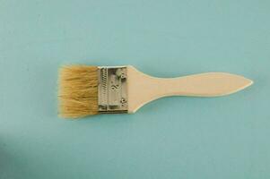 a paint brush with a wooden handle on a blue background photo