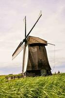 a windmill in the middle of a field photo