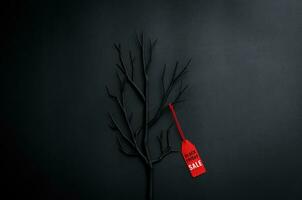 Black tree with branches with word at red price tag on dark background for Black Friday shopping sale concept. photo