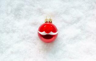 Red baubles set as Santa Claus face put on white snow flakes background for Minimal Christmas holiday concept. photo