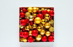 Red and golden baubles put in the box on white background. Christmas holiday concept. photo