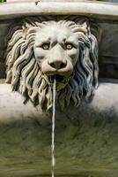 a lion head is on top of a fountain photo
