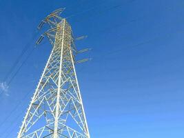 un alto blanco electricidad torre en contra un azul cielo foto