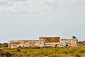 an abandoned building in the desert with graffiti on it photo