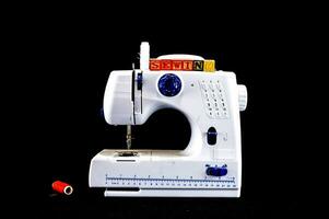 un de coser máquina con hilo foto