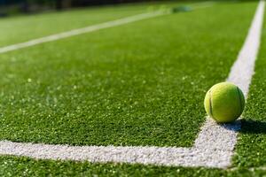 View of empty lawn tennis court with tennis ball photo