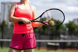 Woman playing tennis holding a racket and smiling photo