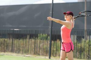 Woman playing tennis holding a racket and smiling photo