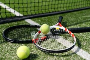 una raqueta de tenis y una pelota de tenis nueva en una cancha de tenis recién pintada foto