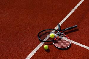 A tennis racket and new tennis ball on a freshly painted tennis court photo