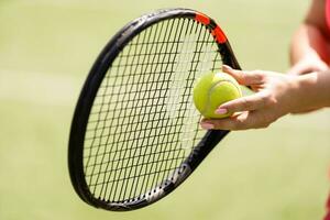 Close up of a tennis player hitting the ball with racket photo