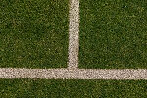 An empty green synthetic tennis court showing the sideline and net photo