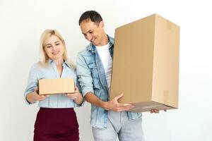 people, delivery, shipping and postal service concept - happy couple opening cardboard box or parcel at home photo