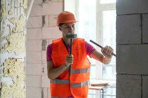 Young worker holding a hammer and a pointed chisel photo