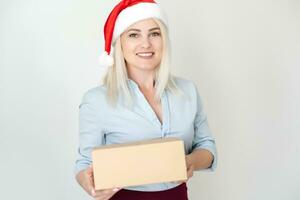 Navidad, Navidad, invierno, felicidad concepto - sonriente mujer en Papa Noel ayudante sombrero con paquete o empaquetar caja foto