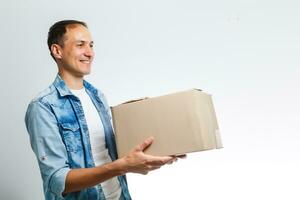 Smiling delivery man giving cardbox on white background photo