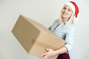 christmas, x-mas, winter, happiness concept - smiling woman in santa helper hat with parcel box photo