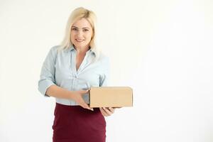 A young beautiful caucasian woman holding a box in her hands. photo