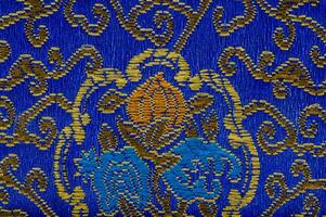 a blue and gold patterned fabric with a floral design photo
