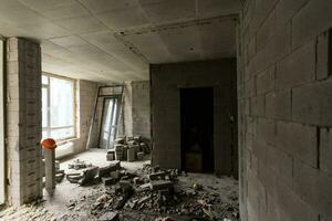 Break the wall for renovation and build the door for entrance of building. Wheelbarrow with broken bricks in site construction. photo