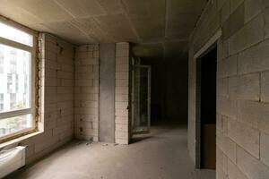 Small apartment without repair in a new building. A room in an unfinished house. Walls of foam block and concrete floor in a tiny apartment. photo