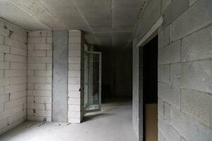 Small apartment without repair in a new building. A room in an unfinished house. Walls of foam block and concrete floor in a tiny apartment. photo