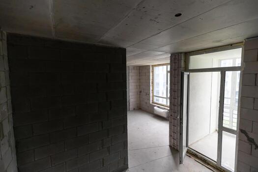 Small apartment without repair in a new building. A room in an unfinished house. Walls of foam block and concrete floor in a tiny apartment. photo