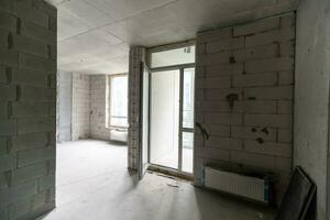 Small apartment without repair in a new building. A room in an unfinished house. Walls of foam block and concrete floor in a tiny apartment. photo