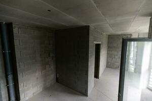 Small apartment without repair in a new building. A room in an unfinished house. Walls of foam block and concrete floor in a tiny apartment. photo