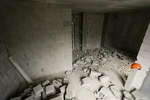 Break the wall for renovation and build the door for entrance of building. Wheelbarrow with broken bricks in site construction. photo