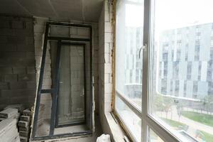 Break the wall for renovation and build the door for entrance of building. Wheelbarrow with broken bricks in site construction. photo