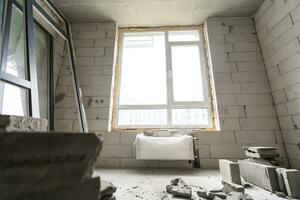 Break the wall for renovation and build the door for entrance of building. Wheelbarrow with broken bricks in site construction. photo