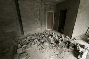 Break the wall for renovation and build the door for entrance of building. Wheelbarrow with broken bricks in site construction. photo
