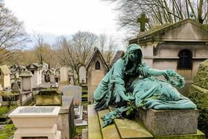 un estatua de un mujer sentado en un lápida sepulcral foto