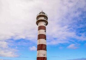 un faro torre con un rojo y blanco rayas foto