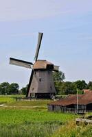 a windmill in the middle of a field photo