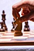 a person is placing a piece on a chess board photo